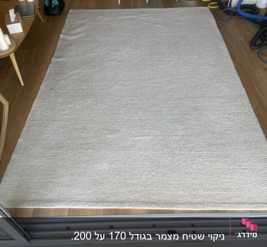 שטיח בהיר על רצפת עץ עם צינורות ניקוי